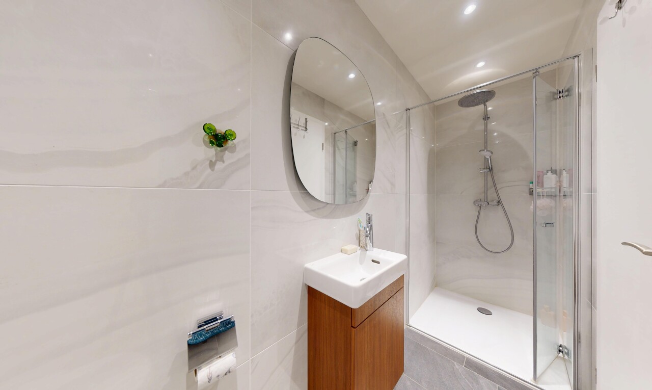full bath featuring vanity, a shower stall, recessed lighting, and tile walls