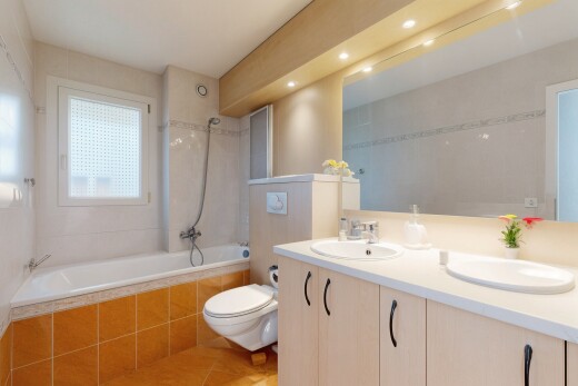 salle de bains avec douche-bain combinés, miroir, salle de bain complète, double vasque, et sol en carrelage