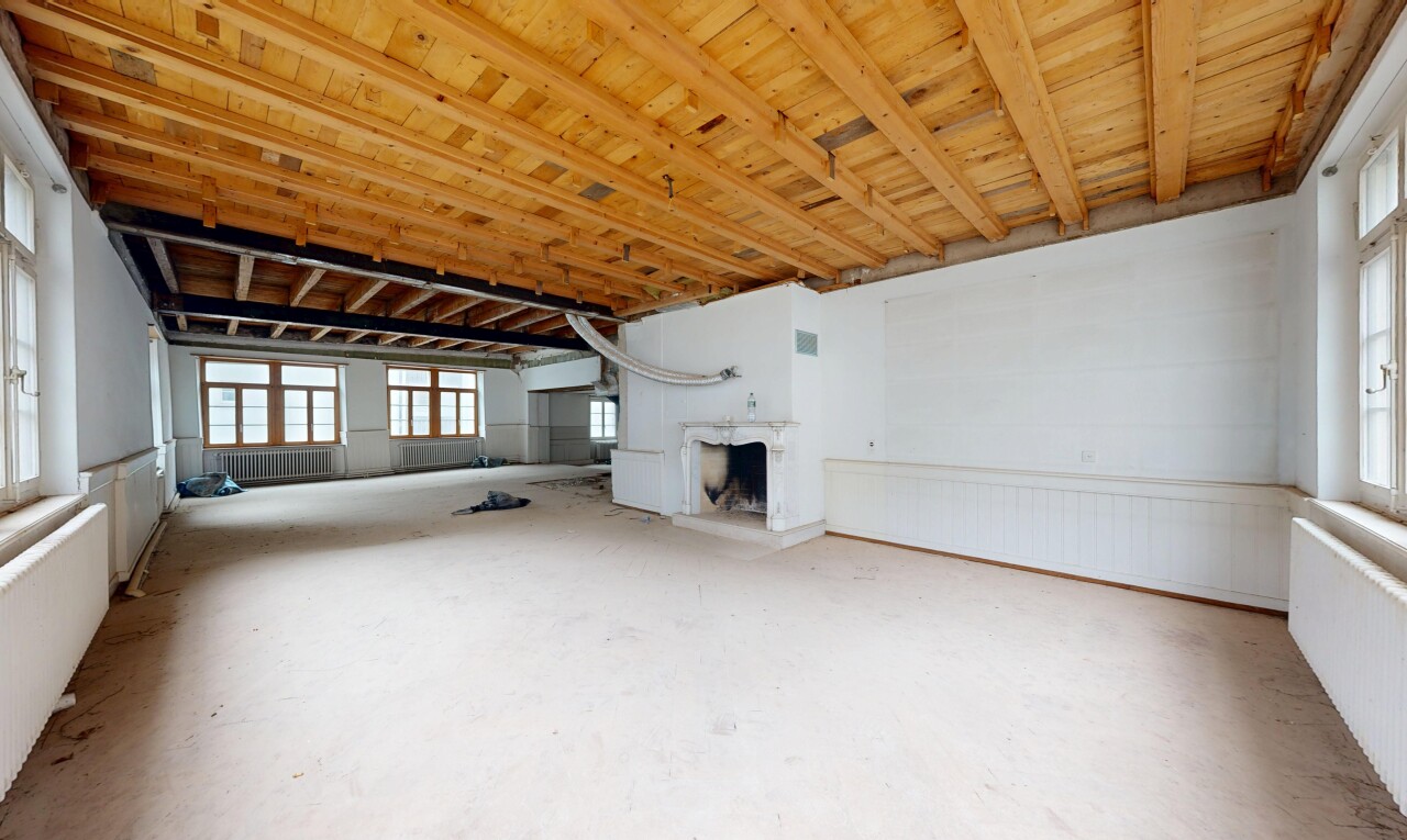 leerer raum mit inside community, betonboden, concrete floor, kamin, und natürliches licht