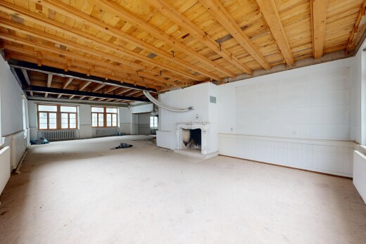 pièce vide avec inside community, sol en béton, concrete floor, cheminée, et lumière naturelle