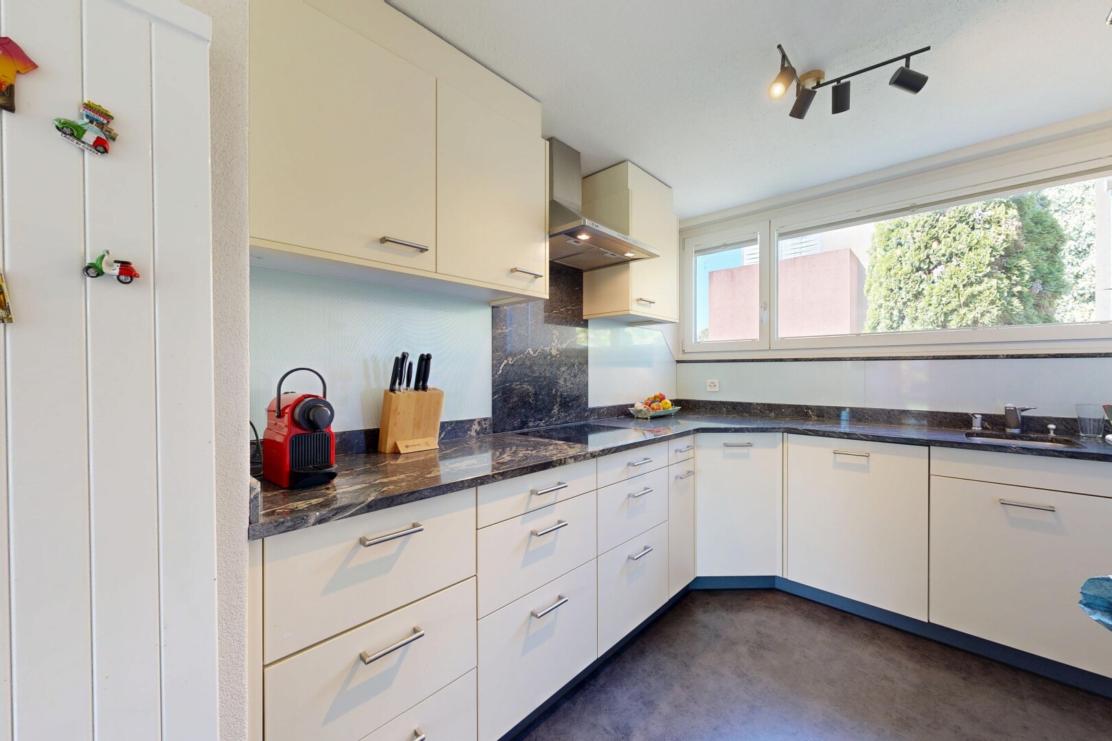 küche mit dark countertops, dunstabzugshaube, dark floor, natural light, und natürliches licht