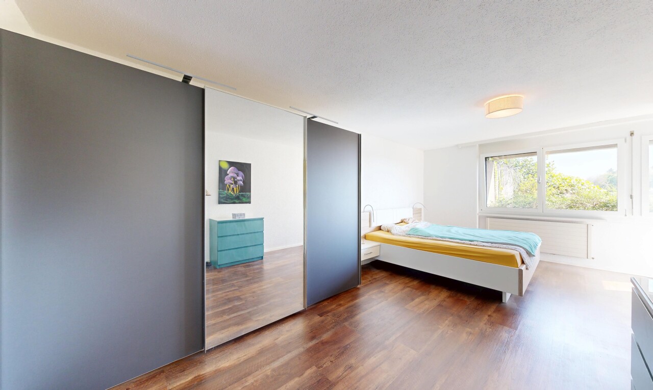 zimmer / schlafzimmer mit inside property, natural light, natürliches licht, wood finish floor, und holzfußboden