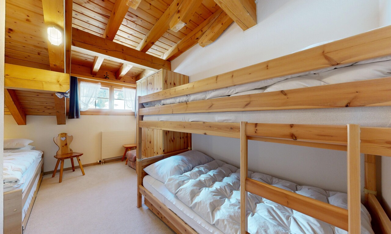 room / bedroom featuring light colored carpet and a wood ceiling with exposed beams