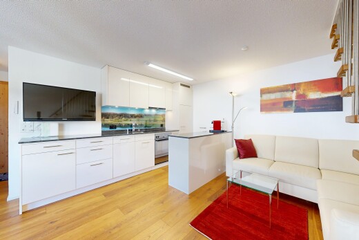 cuisine avec dark countertops, plans de travail, télévision, wood finish floor, et sol en finition bois
