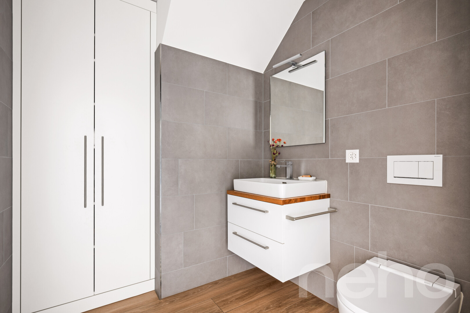 salle de bains avec miroir, lavabo (ou coiffeuse selon le contexte), tile wall, mur en carrelage, et inside property
