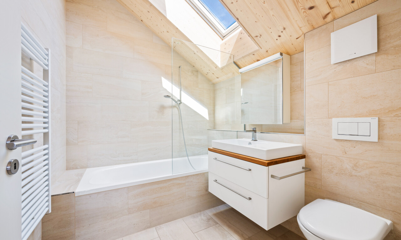 salle de bains avec chauffe-serviettes, lavabo (ou coiffeuse selon le contexte), salle de bain complète, light floor, et mur en carrelage