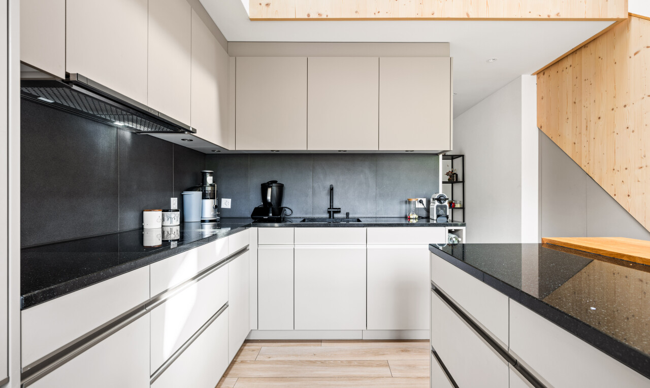 cuisine avec dark countertops, wood finish floor, sol en finition bois, inside property, et backsplash