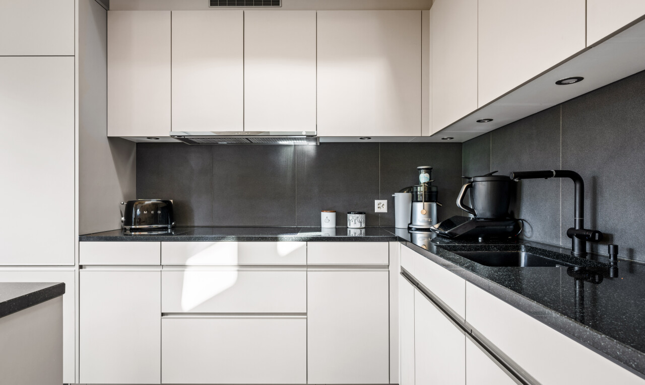 cuisine avec dark countertops, inside property, white cabinets, armoires blanches, et plans de travail en pierre