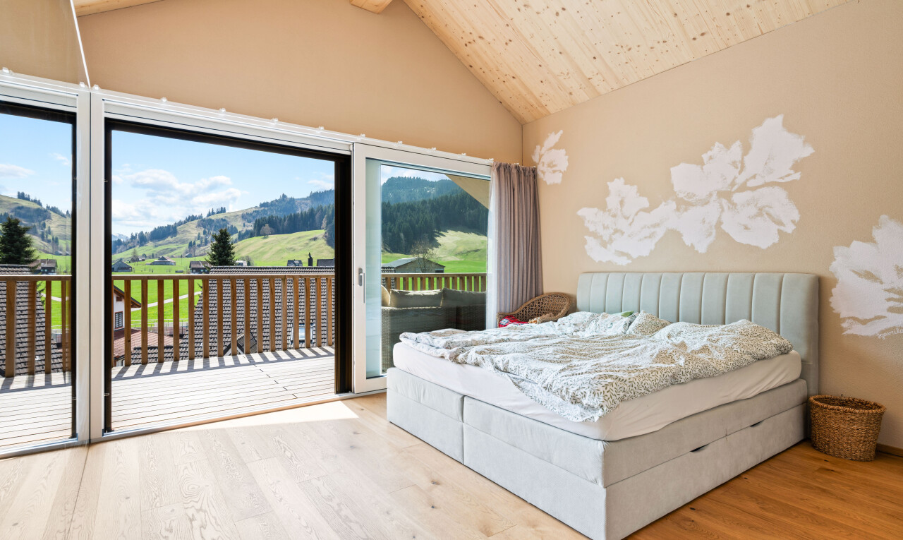 chambre avec inside property, accès à l'extérieur, cloison sèche, drywall, et sol en finition bois