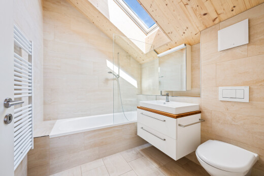 salle de bains avec chauffe-serviettes, lavabo (ou coiffeuse selon le contexte), salle de bain complète, light floor, et mur en carrelage