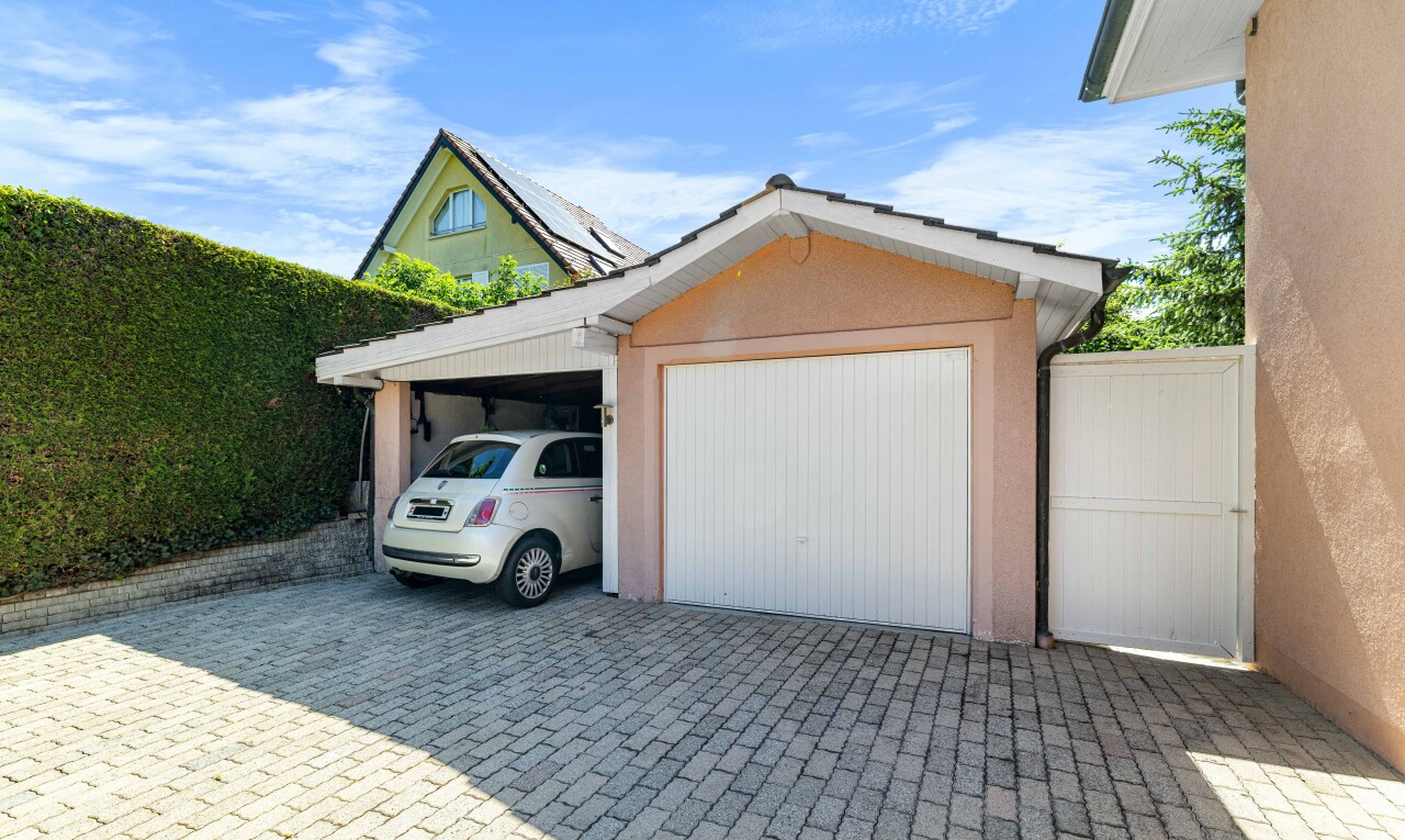 façade avec day time, structure extérieure, garage, bardage en stuc, et property visible