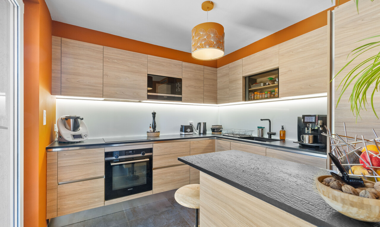 küche mit schränke mit flachen paneelen, pendelleuchte, hellbraune schränke, ofen, und inside property