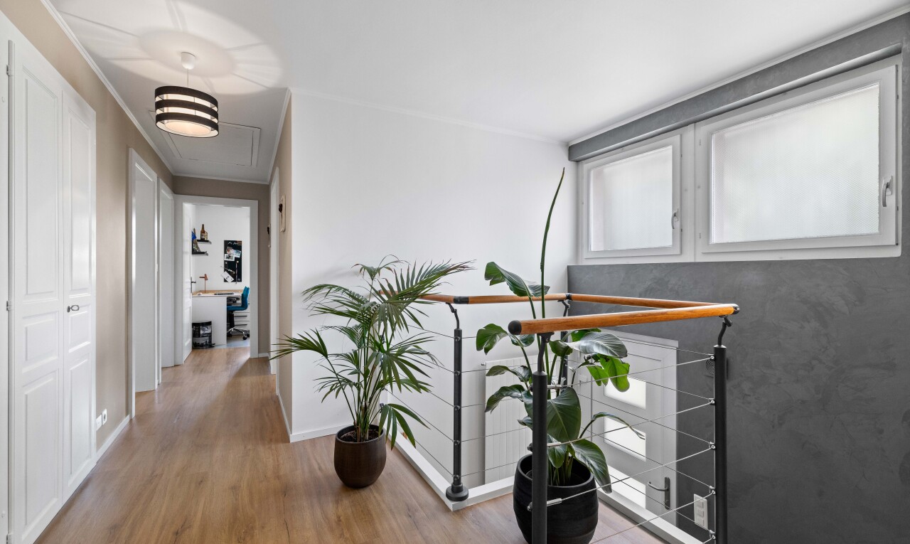 couloir avec sol en finition bois, wood finish floor, inside property, lumière naturelle, et natural light