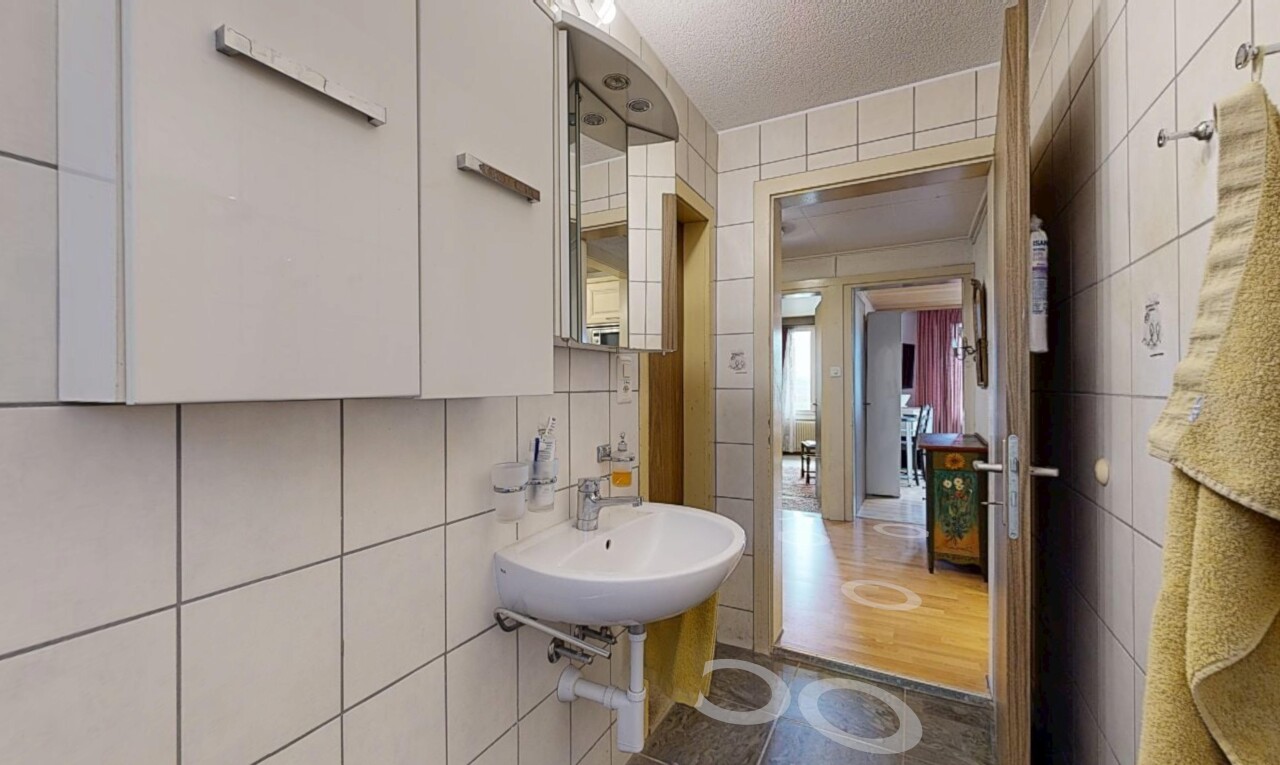 salle de bains avec mur en carrelage, tile wall, plafond texturé, textured ceiling, et miroir
