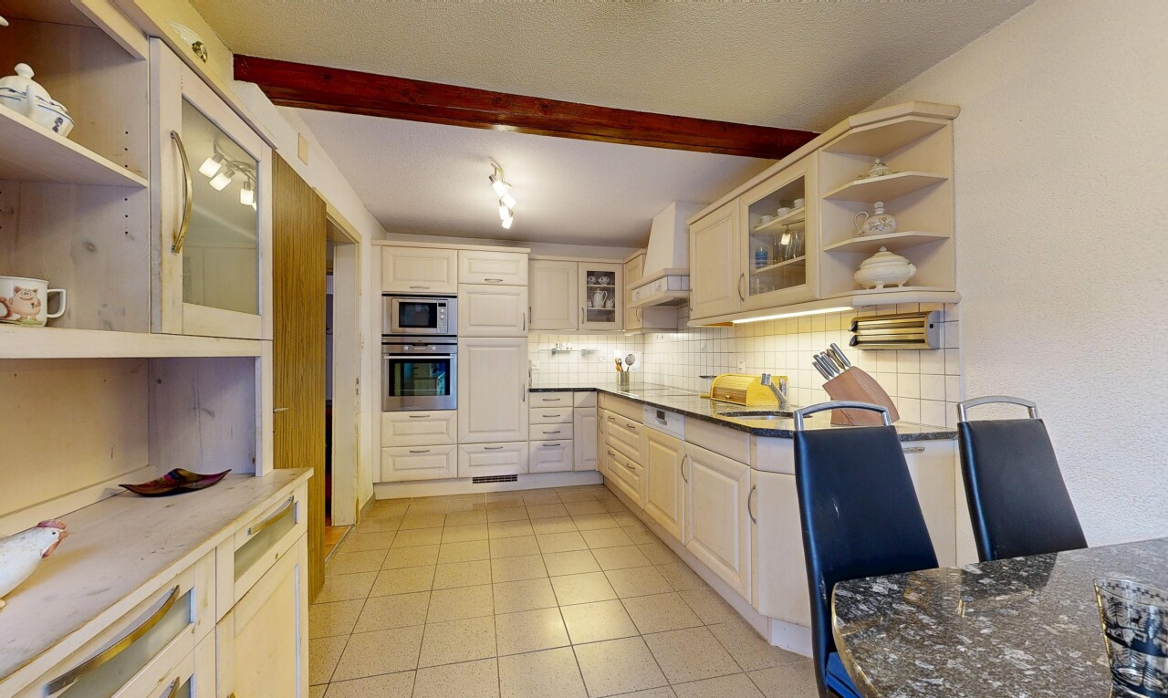 cuisine avec étagères ouvertes, armoires avec insert en verre, inside property, plans de travail en pierre, et four