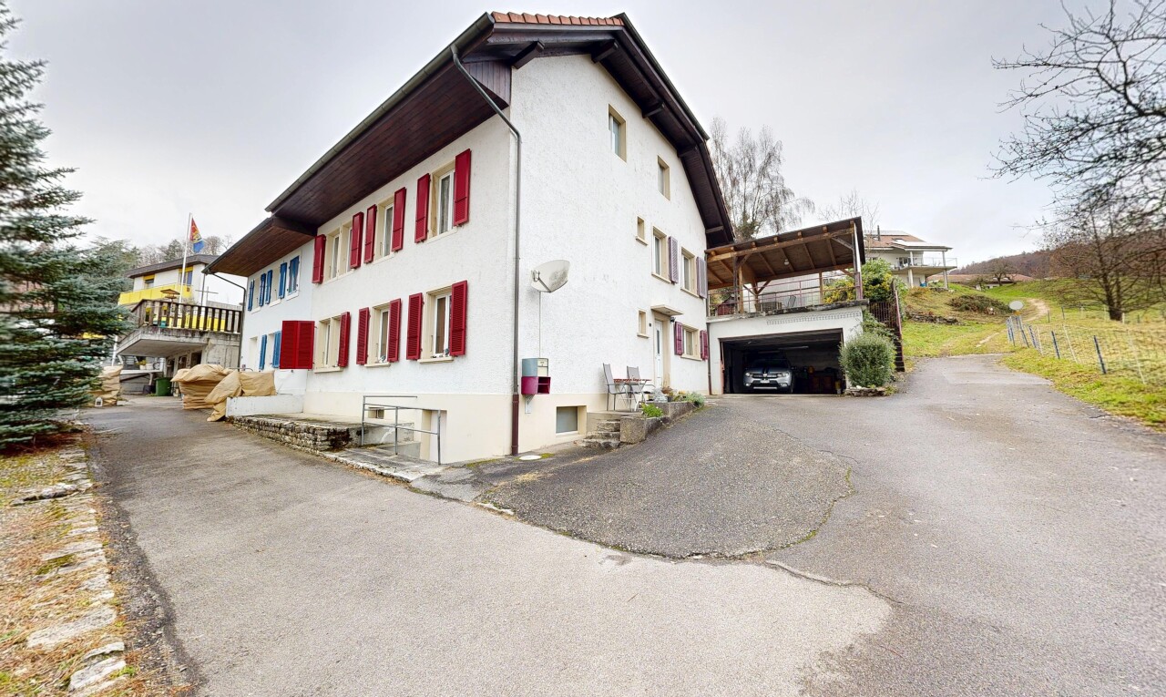 façade avec property visible, overcast, bardage en stuc, allée, et garage
