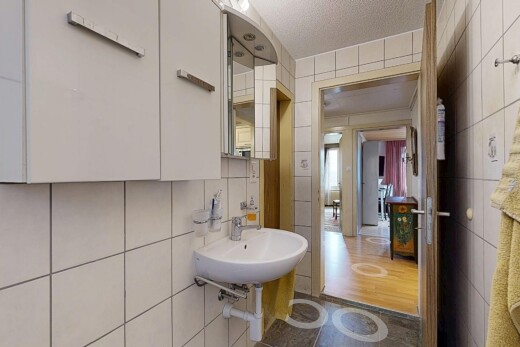 salle de bains avec mur en carrelage, tile wall, plafond texturé, textured ceiling, et miroir