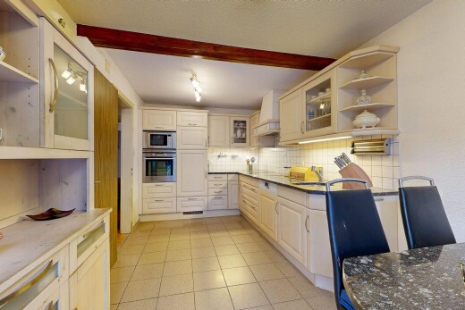 cuisine avec étagères ouvertes, armoires avec insert en verre, inside property, plans de travail en pierre, et four