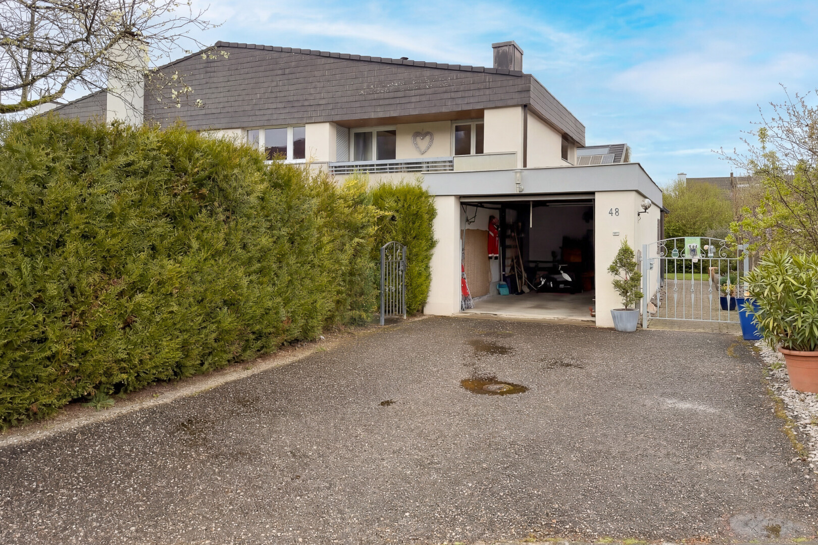 façade avec cheminée, portail, day time, property visible, et garage