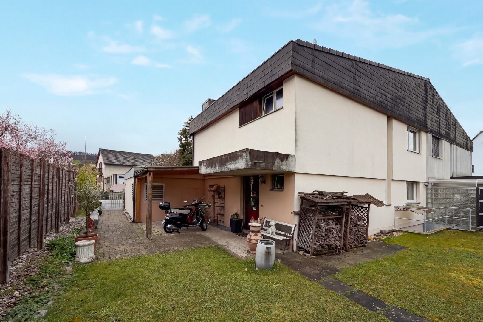 außenansicht mit zaun, rasen, property visible, stuckverkleidung, und tor