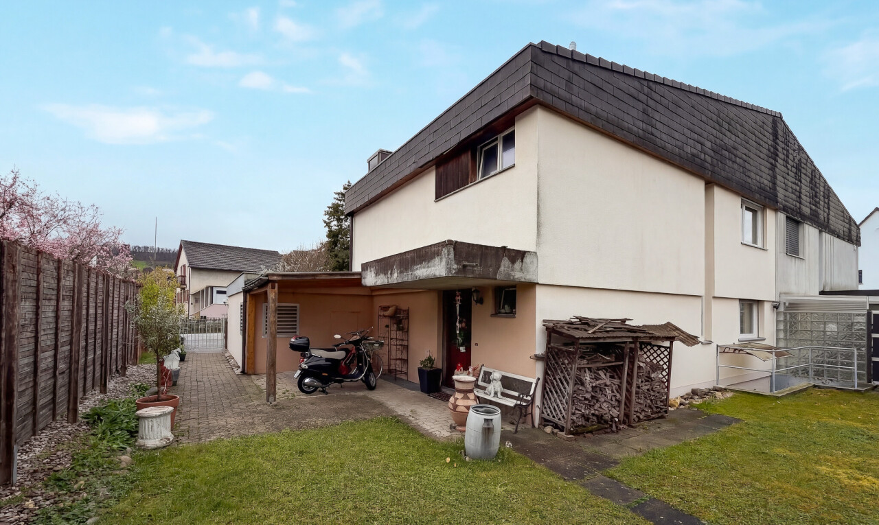 außenansicht mit zaun, rasen, property visible, stuckverkleidung, und tor