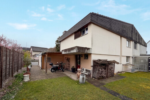 außenansicht mit zaun, rasen, property visible, stuckverkleidung, und tor