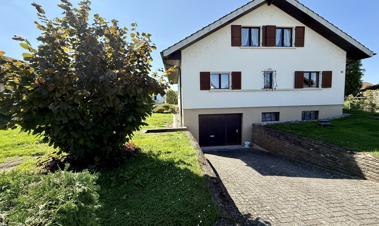façade avec bardage en stuc, garage intégré, allée, property visible, et day time