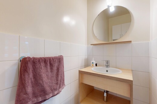salle de bains avec miroir, tile wall, mur en carrelage, inside property, et évier