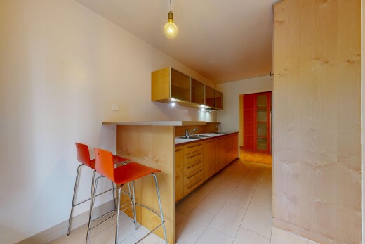 cuisine avec inside property, armoires à panneau plat, drywall, cloison sèche, et éclairage suspendu