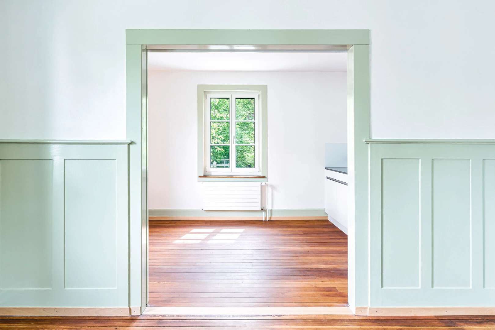 spare room featuring radiator, a decorative wall, and wood finished floors