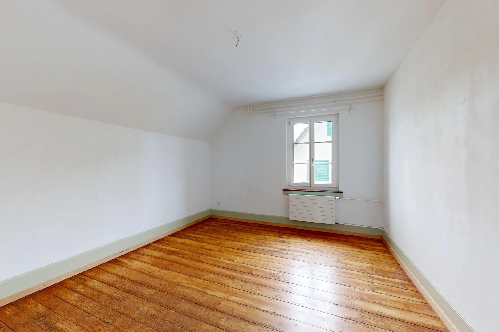 spare room featuring light wood-style floors, radiator, and vaulted ceiling
