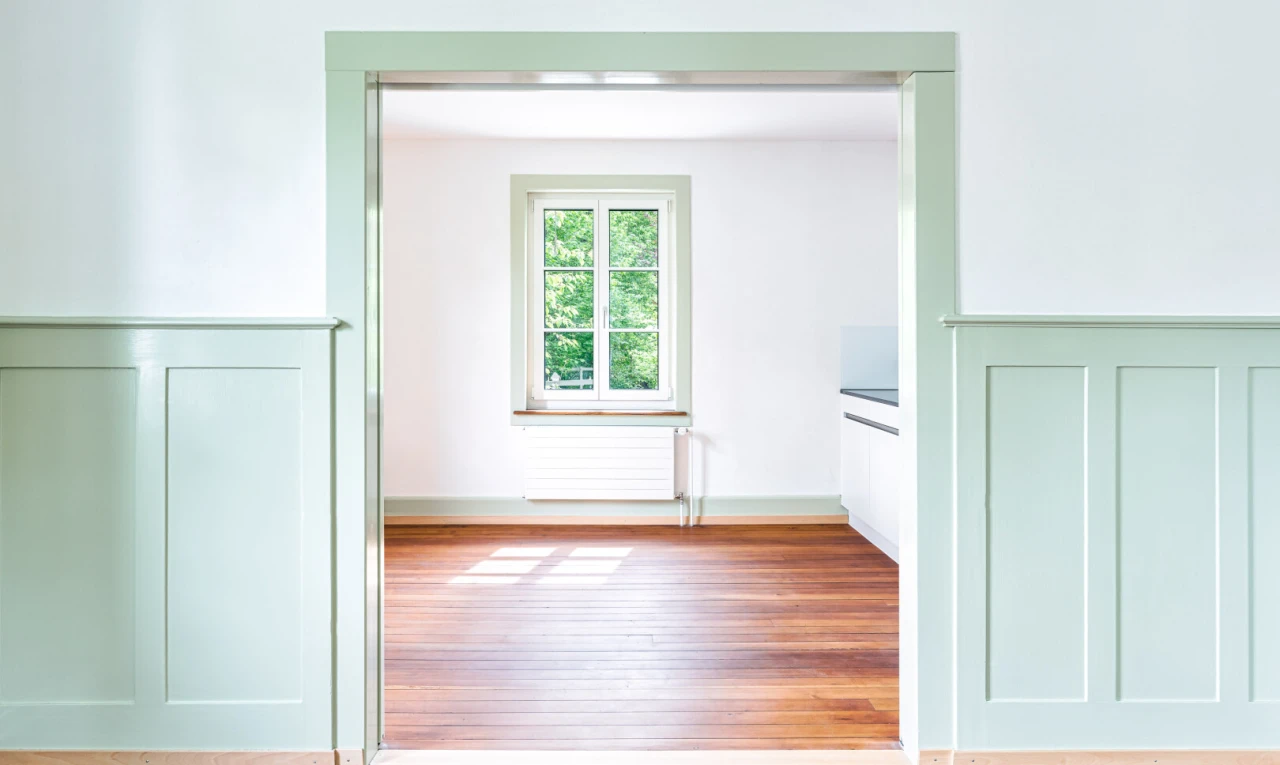 spare room featuring radiator, a decorative wall, and wood finished floors