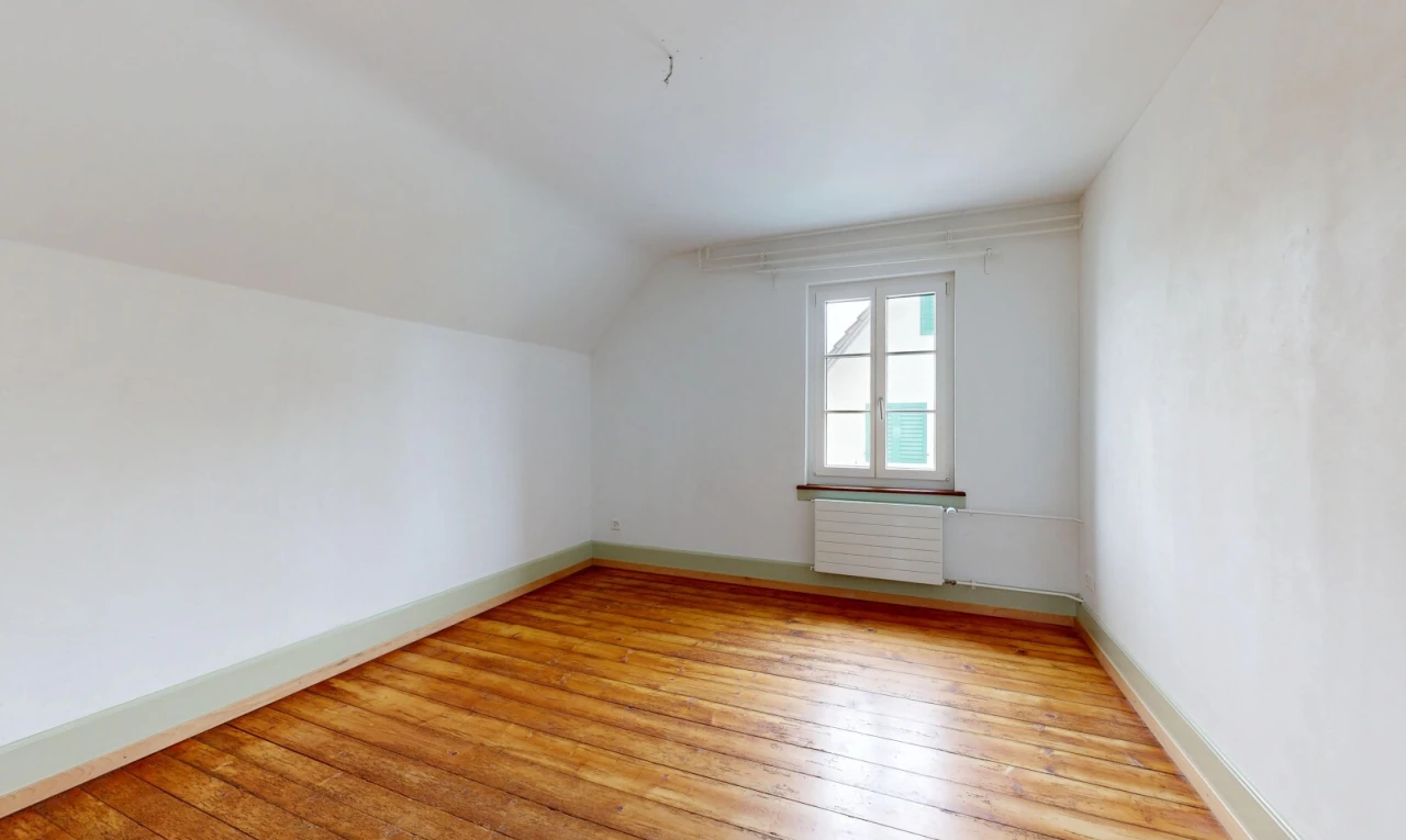 spare room featuring light wood-style floors, radiator, and vaulted ceiling