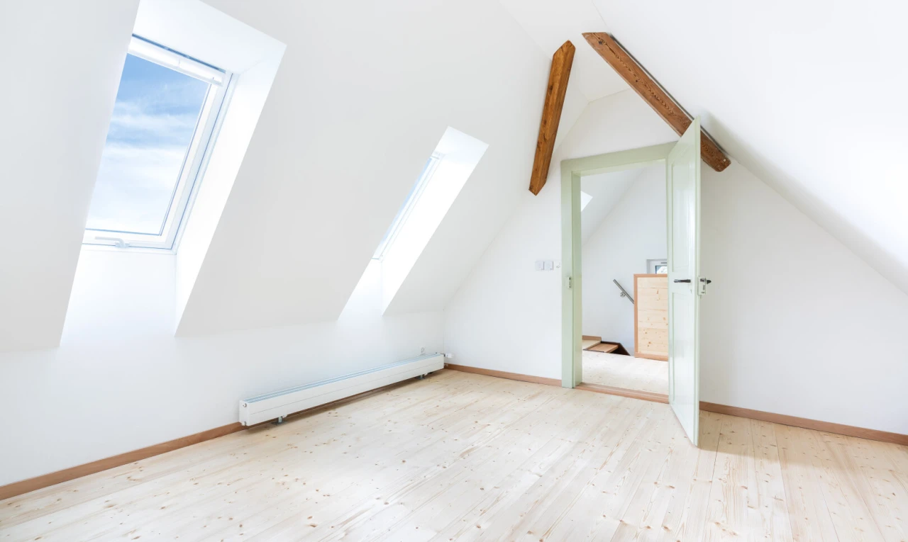 spare room with a baseboard radiator, light wood-style floors, and vaulted ceiling with beams