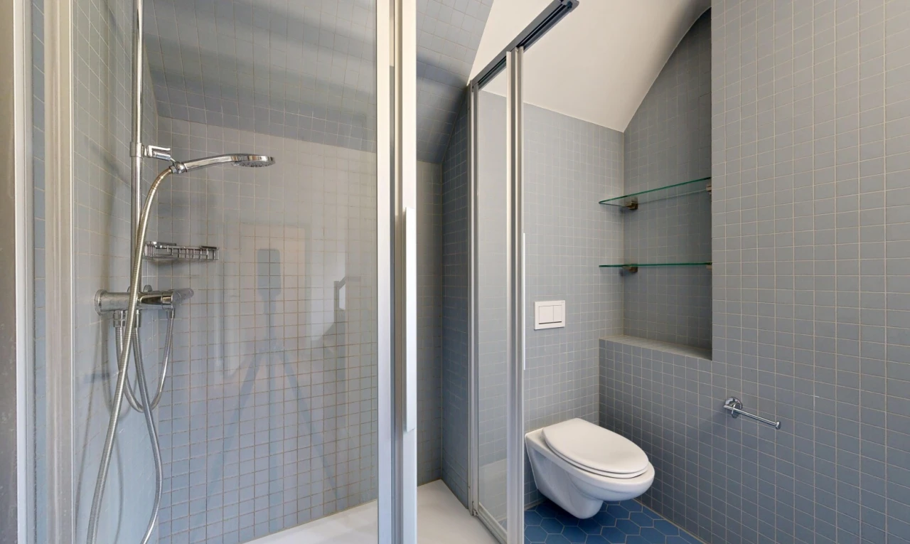 full bathroom featuring a shower stall, tile walls, lofted ceiling, and tile patterned flooring