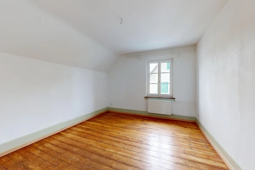 spare room featuring light wood-style floors, radiator, and vaulted ceiling