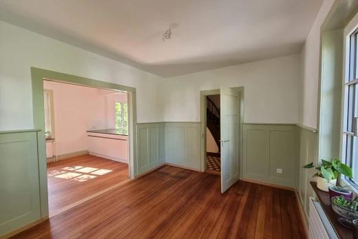 spare room featuring a wainscoted wall, a decorative wall, and hardwood / wood-style floors