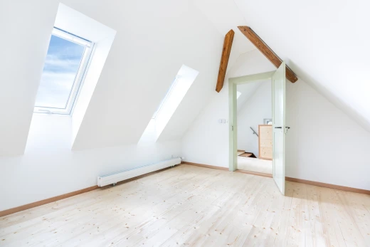 spare room with a baseboard radiator, light wood-style floors, and vaulted ceiling with beams