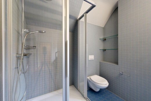 full bathroom featuring a shower stall, tile walls, lofted ceiling, and tile patterned flooring