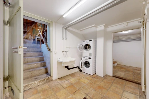laundry area with stairs and stacked washer and dryer