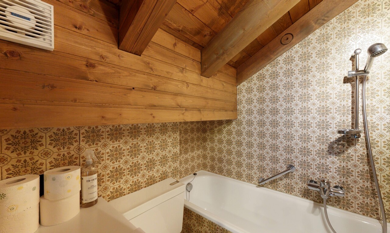 salle de bains avec mur en papier peint, wallpaper wall, inside property, salle de bain complète, et toilette