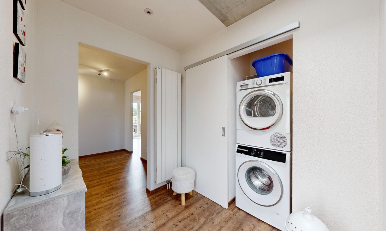 wäschekammer mit waschturm, holzfußboden, wood finish floor, kühler, und inside property