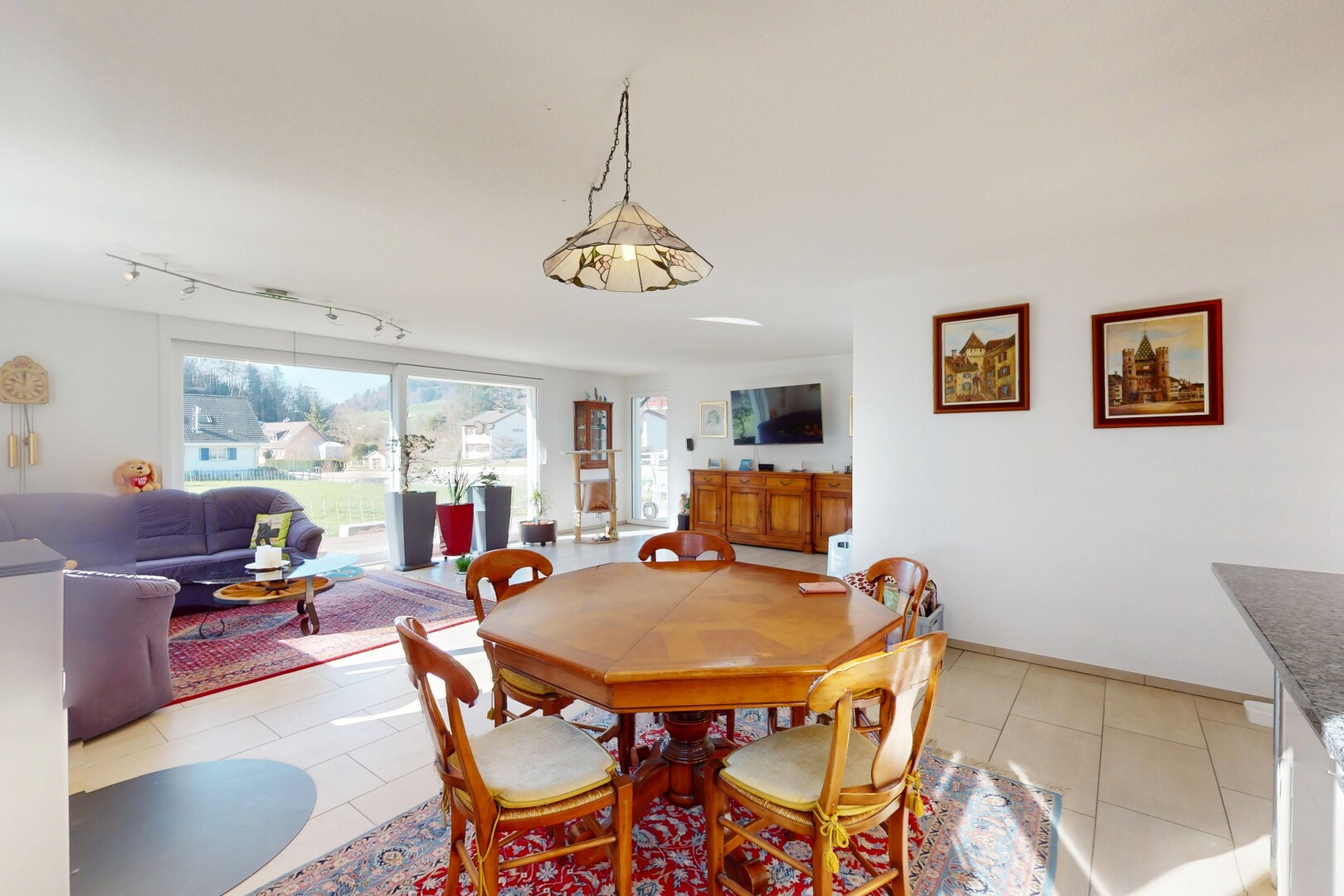 salon / salle à manger avec lumière naturelle, télévision, cloison sèche, et sol en carrelage