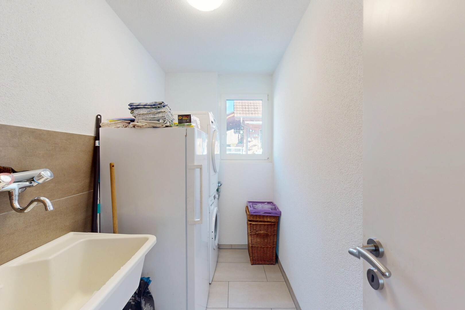 salle de bains avec lumière naturelle, évier, et sol en carrelage