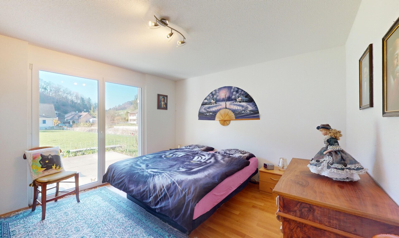 chambre avec cloison sèche, lumière naturelle, accès à l'extérieur, et sol en finition bois