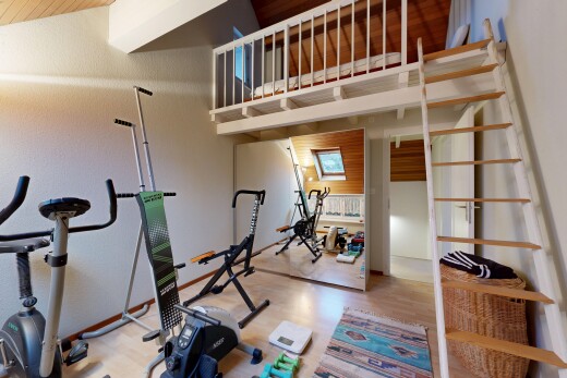gym avec inside property, drywall, cloison sèche, wood finish floor, et sol en finition bois
