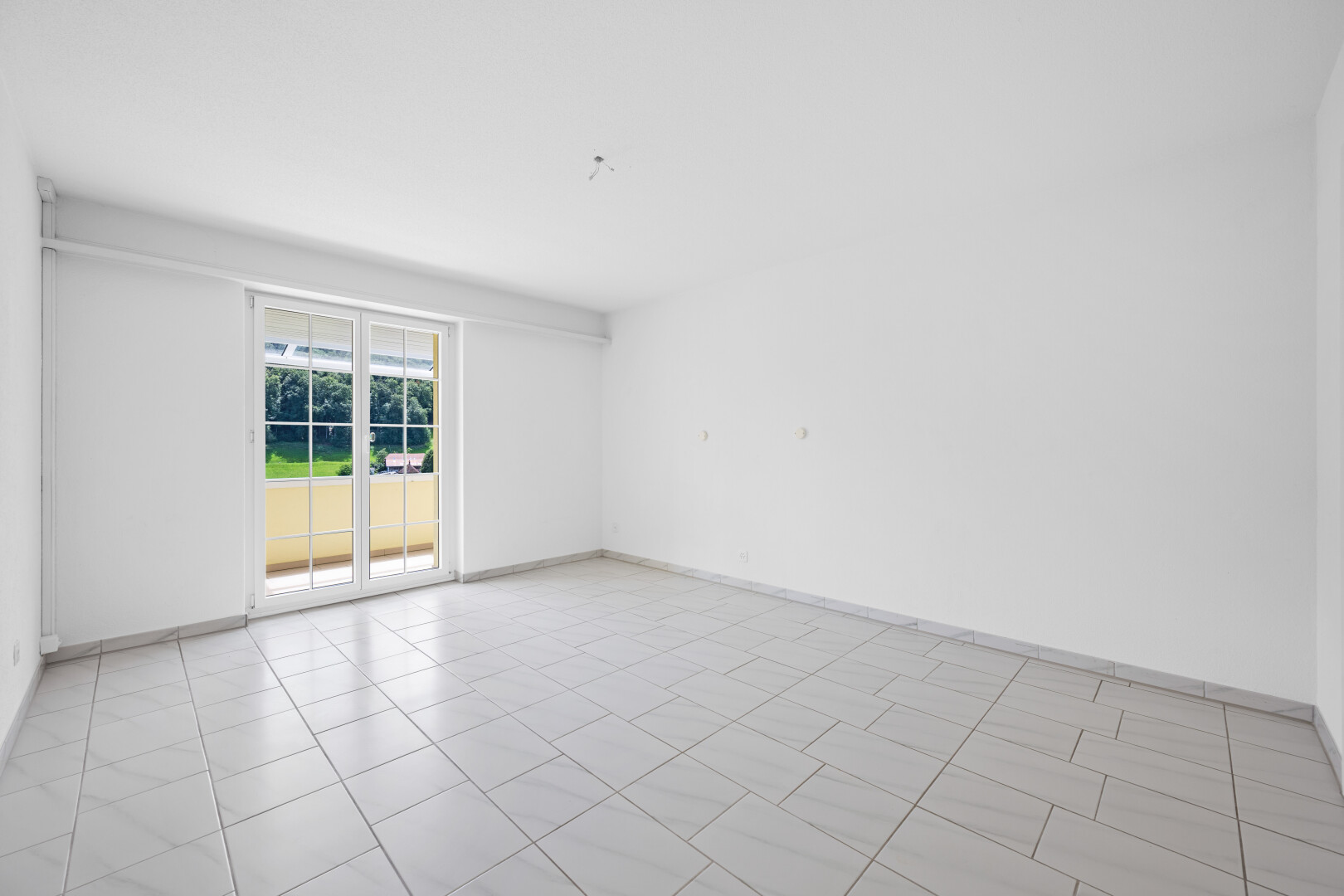 empty room featuring light tile patterned flooring and baseboards