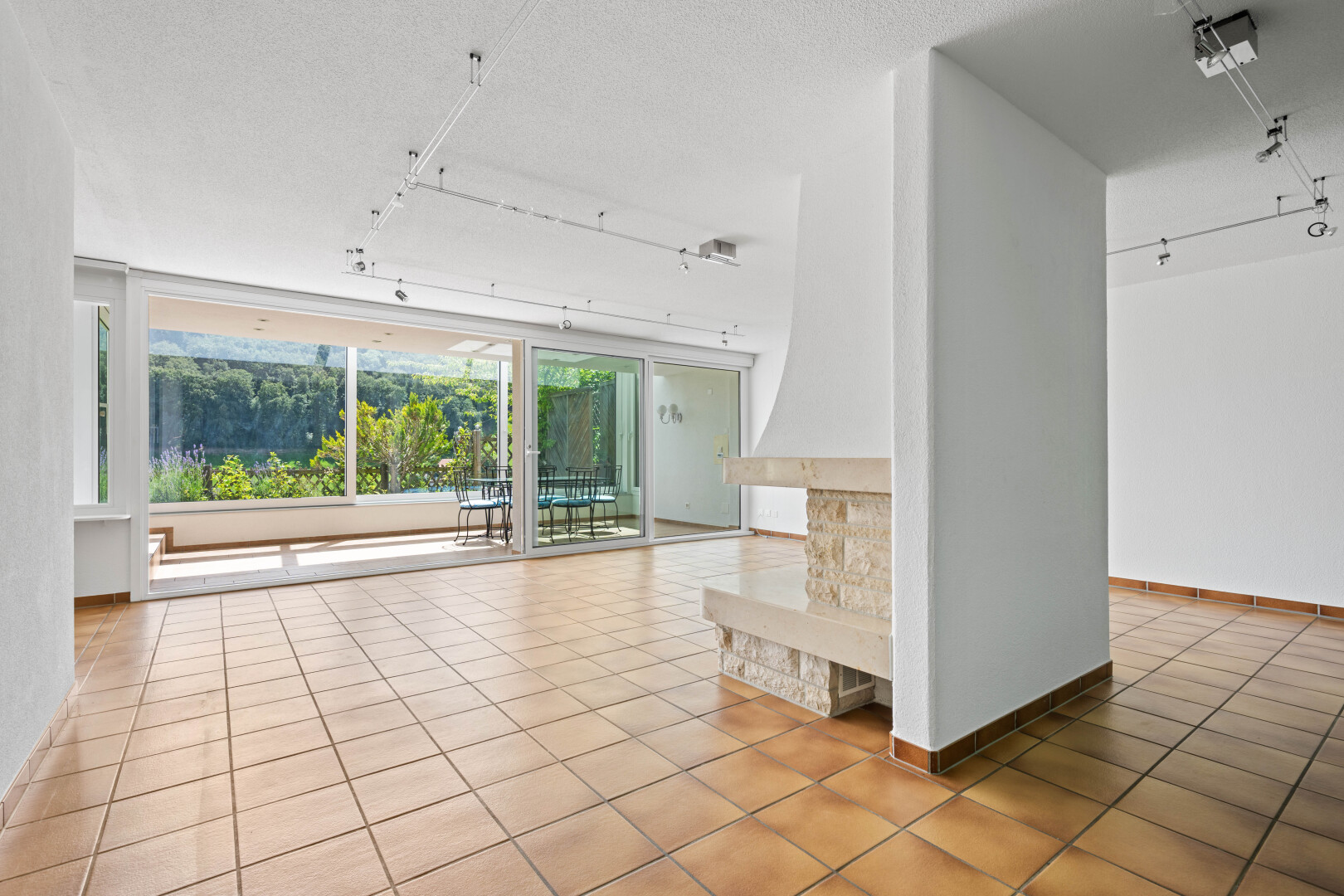 unfurnished room featuring rail lighting, light tile patterned floors, and a textured ceiling