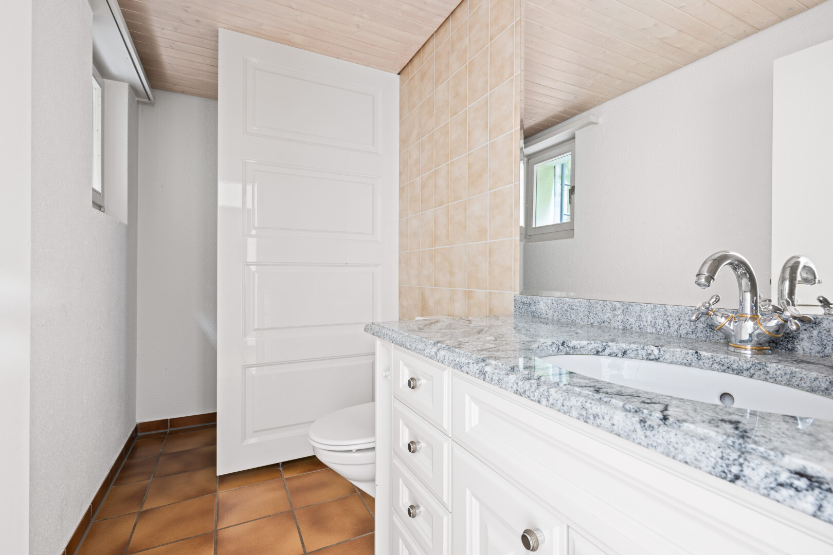 half bathroom featuring vanity, dark tile patterned flooring, and wooden ceiling