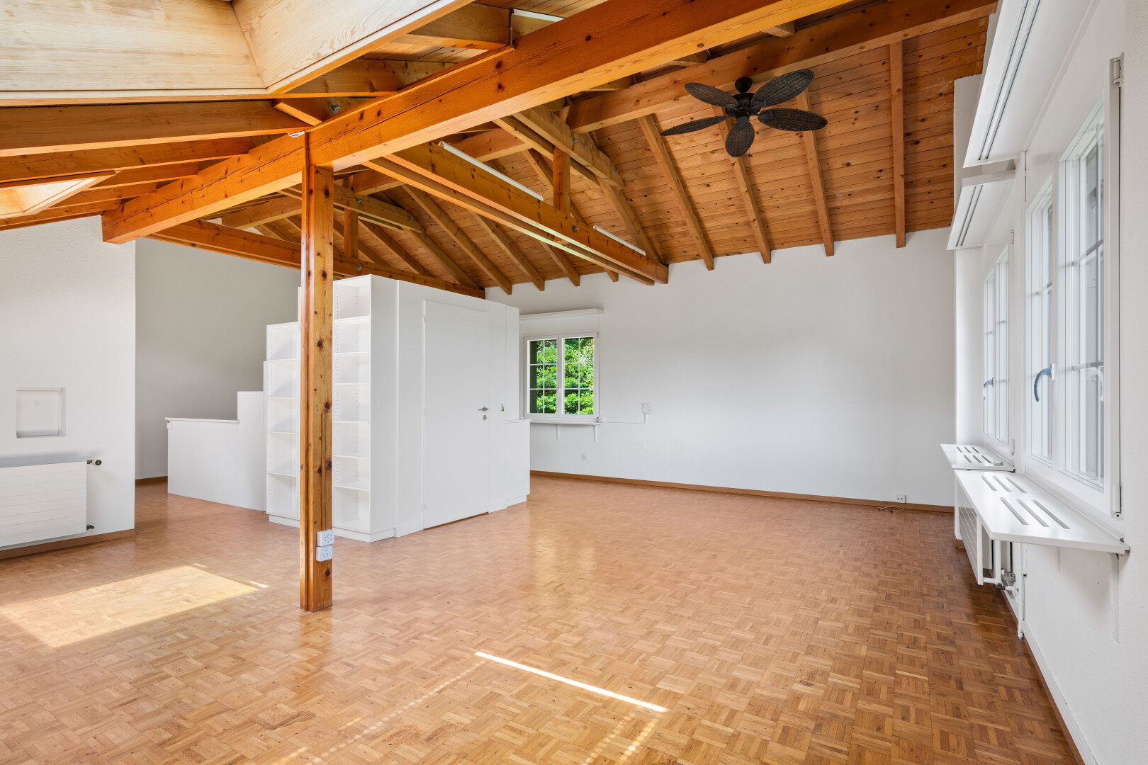 empty room featuring radiator, ceiling fan, parquet flooring, and a wood ceiling with exposed beams